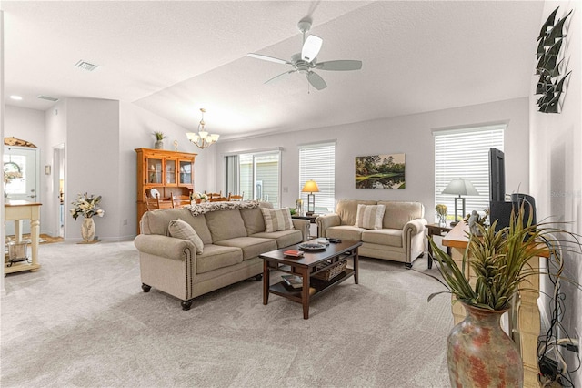 carpeted living room with ceiling fan with notable chandelier, vaulted ceiling, and a textured ceiling