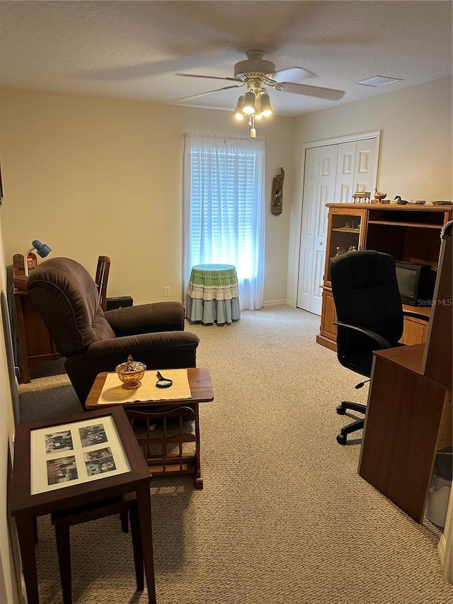 carpeted office space with ceiling fan