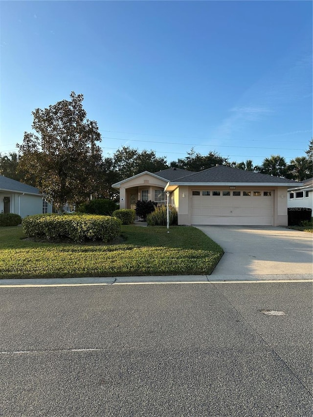 ranch-style home featuring a garage and a front lawn