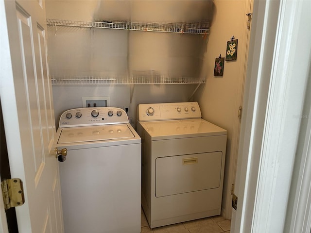 laundry area with light tile patterned floors and washer and clothes dryer