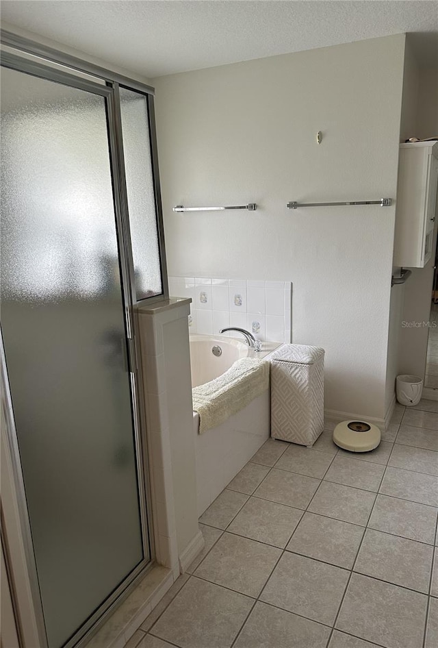 bathroom featuring tile patterned flooring, shower with separate bathtub, and a textured ceiling