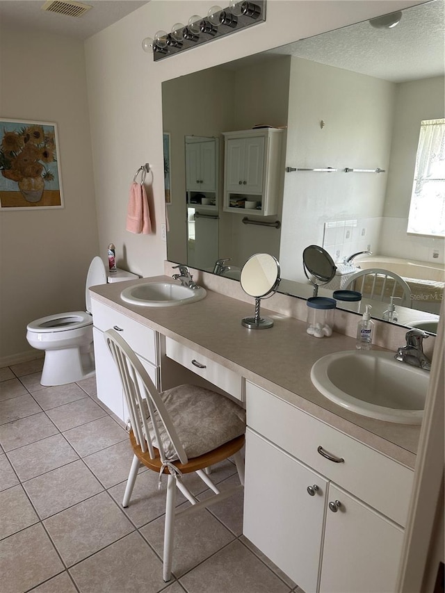 bathroom with vanity, tile patterned floors, toilet, and a textured ceiling