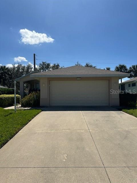 view of front facade with an attached garage, concrete driveway, and stucco siding