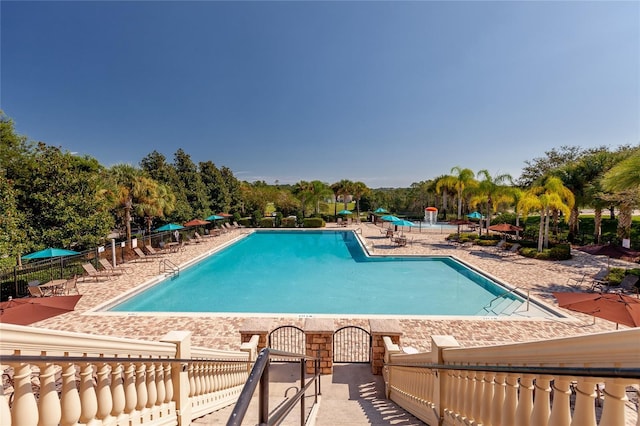 community pool featuring fence and a patio