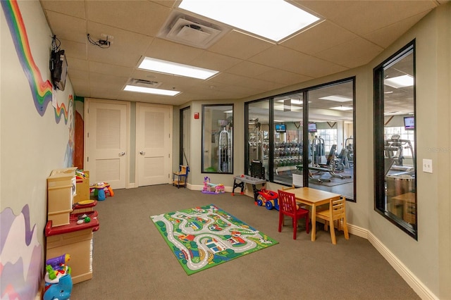 recreation room with a paneled ceiling, carpet flooring, visible vents, and baseboards