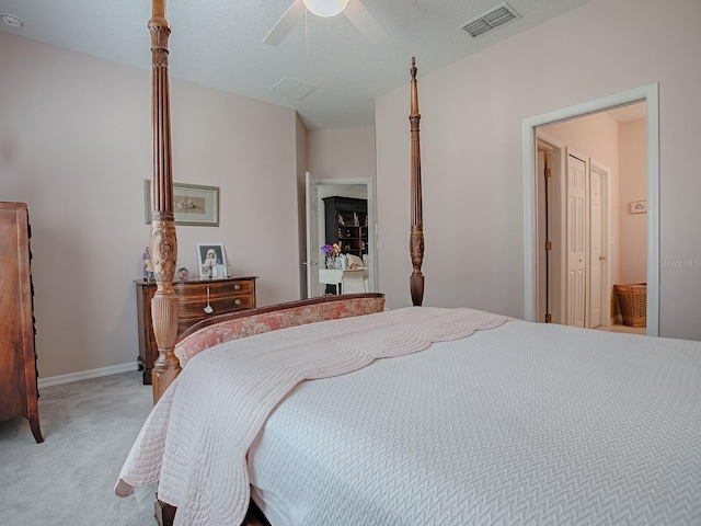 bedroom featuring ceiling fan, a textured ceiling, light carpet, visible vents, and baseboards