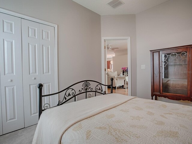 carpeted bedroom featuring visible vents and a closet