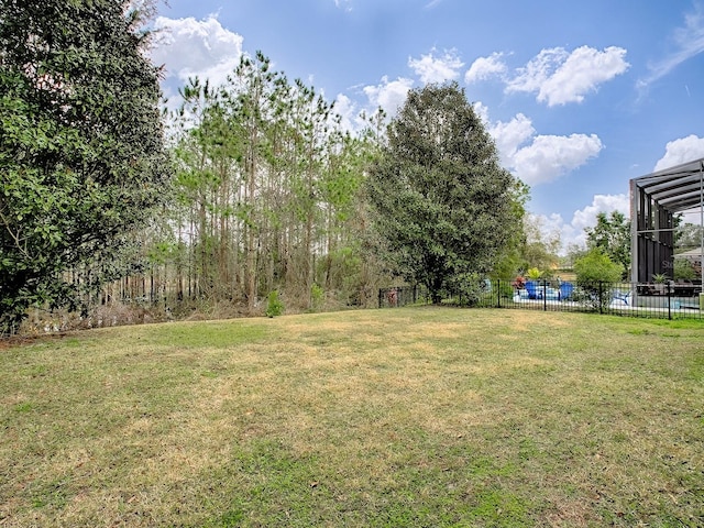 view of yard featuring a lanai and fence