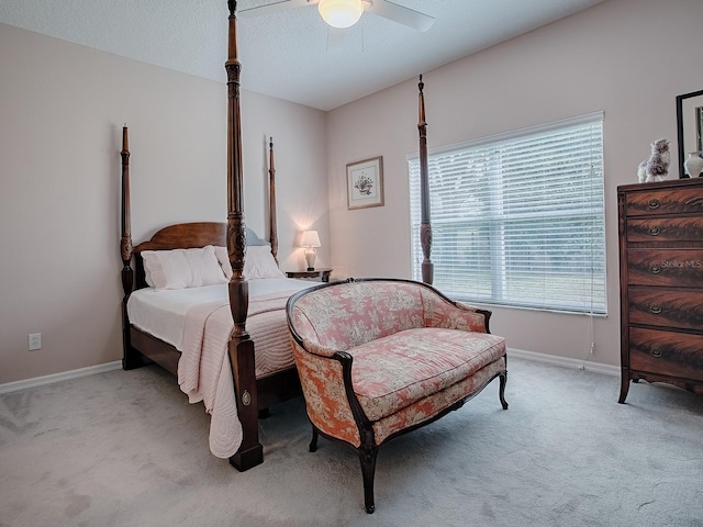 bedroom with a textured ceiling, baseboards, a ceiling fan, and light colored carpet