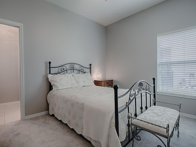 bedroom featuring baseboards and light colored carpet