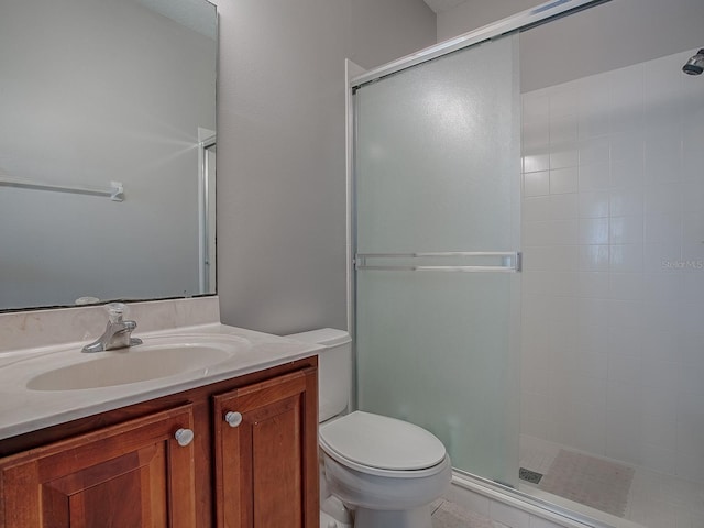 full bath featuring toilet, a stall shower, and vanity