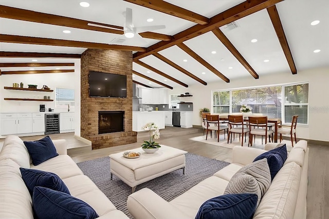 living area with lofted ceiling with beams, light wood-type flooring, wine cooler, and visible vents