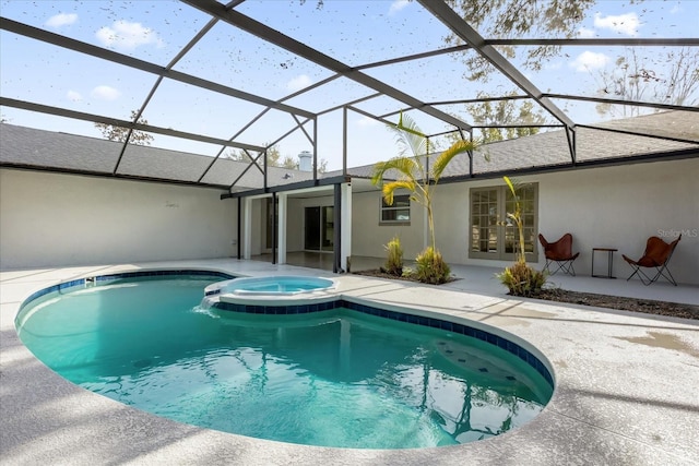 view of swimming pool featuring glass enclosure, a patio area, and a pool with connected hot tub