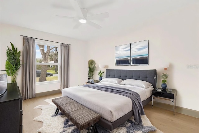 bedroom featuring light wood-style floors, baseboards, and a ceiling fan