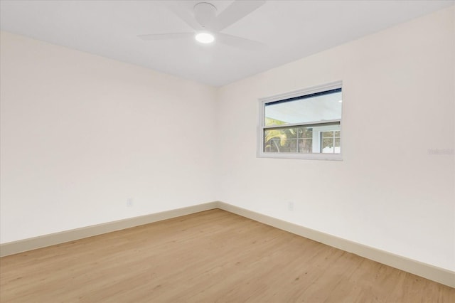 unfurnished room with wood finished floors, a ceiling fan, and baseboards