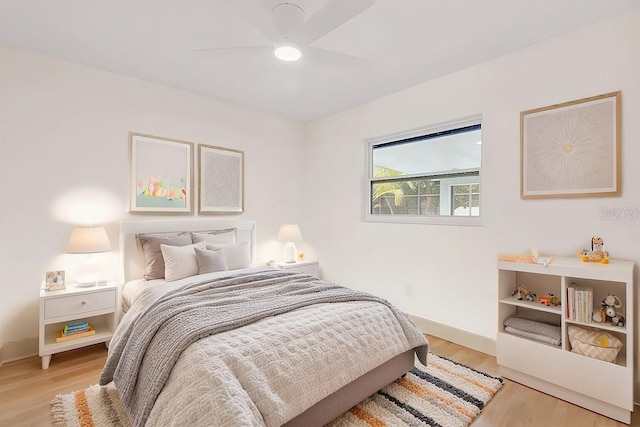 bedroom with light wood-type flooring, baseboards, and a ceiling fan