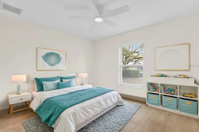 bedroom with light wood finished floors, visible vents, and baseboards