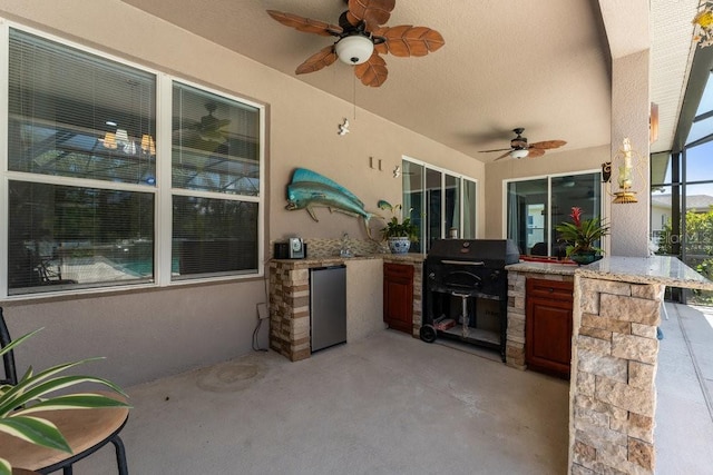 view of patio with ceiling fan, exterior kitchen, a grill, and a lanai