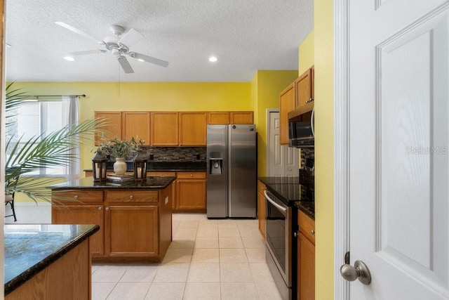 kitchen featuring brown cabinets, light tile patterned floors, tasteful backsplash, and stainless steel appliances