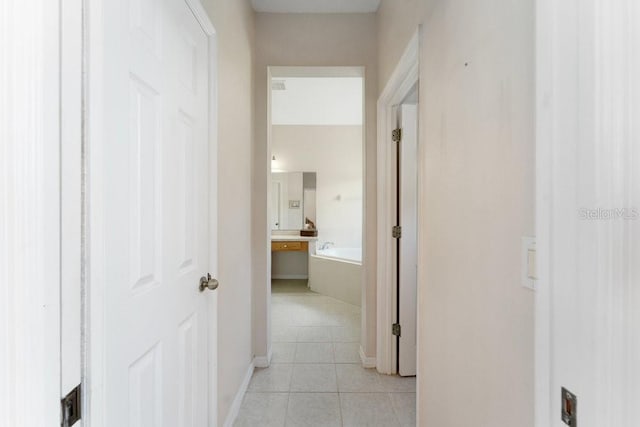 hall with light tile patterned floors and baseboards