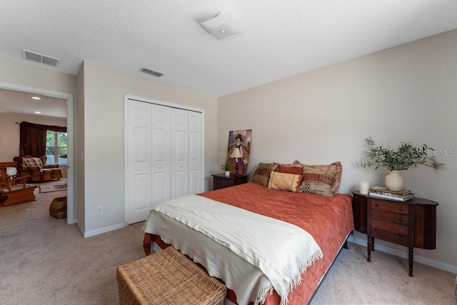 bedroom with baseboards, visible vents, a closet, and light colored carpet