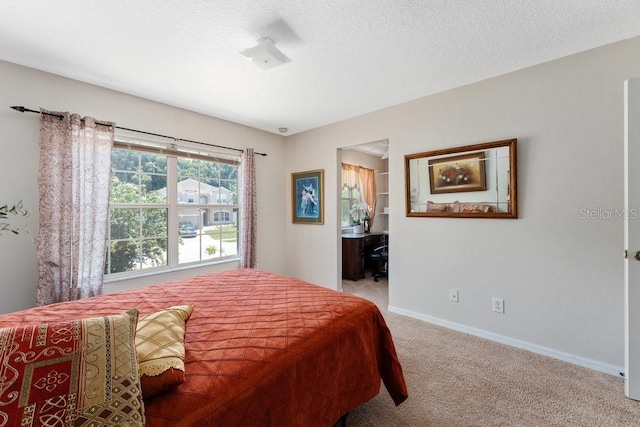 bedroom with light colored carpet, a textured ceiling, and baseboards