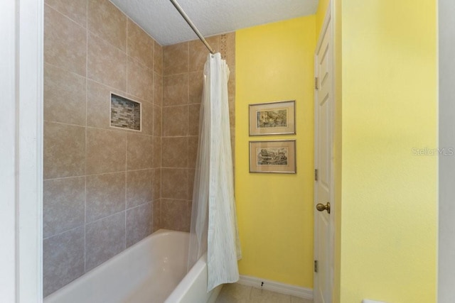 full bath featuring tile patterned floors, baseboards, and shower / bath combo with shower curtain