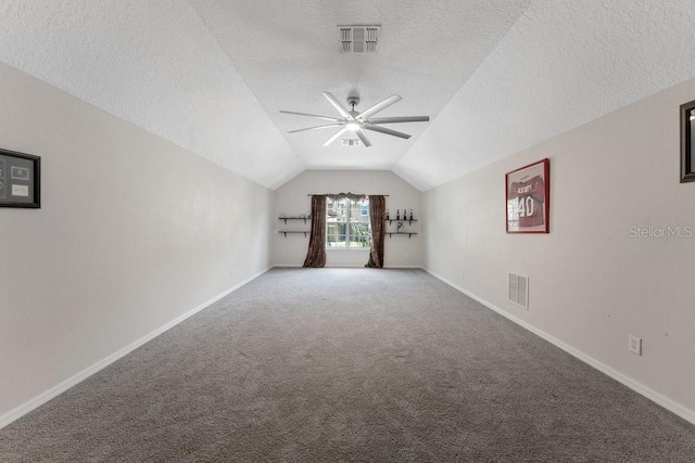 interior space featuring ceiling fan, visible vents, vaulted ceiling, and baseboards