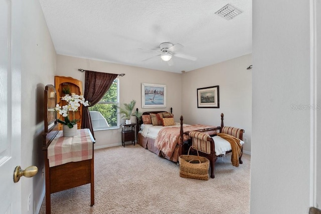 carpeted bedroom featuring visible vents, ceiling fan, a textured ceiling, and baseboards