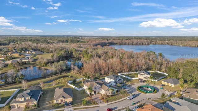 drone / aerial view with a residential view, a water view, and a wooded view