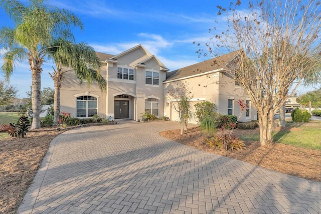 view of front of house with decorative driveway and stucco siding