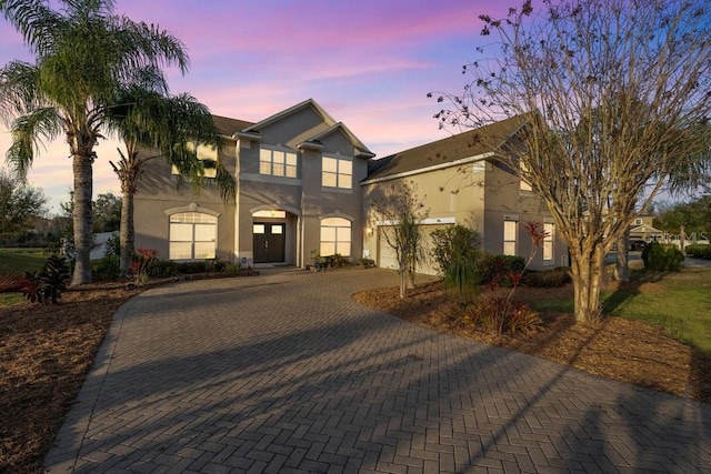 view of front of house with decorative driveway and stucco siding