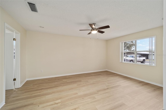 empty room featuring ceiling fan, light hardwood / wood-style flooring, and a textured ceiling