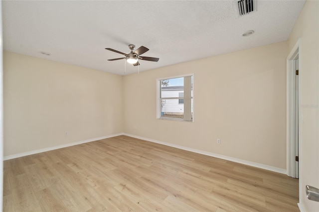 empty room with ceiling fan, light hardwood / wood-style floors, and a textured ceiling