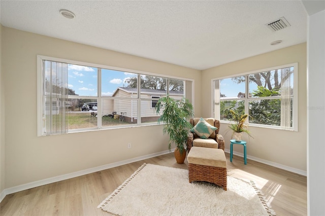 living area with a textured ceiling and light wood-type flooring