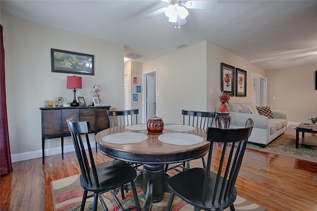 dining space featuring hardwood / wood-style flooring and a textured ceiling