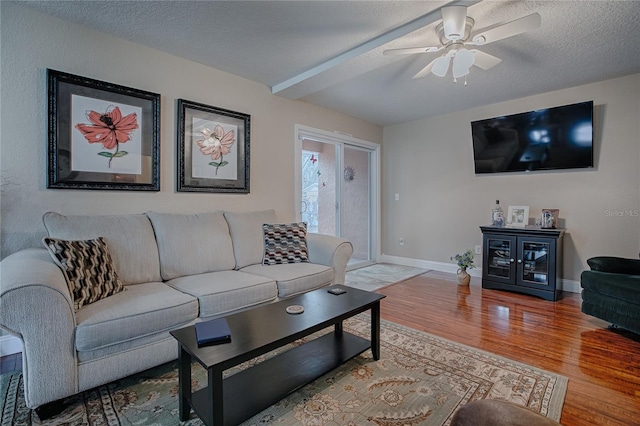 living room with ceiling fan, hardwood / wood-style floors, and a textured ceiling