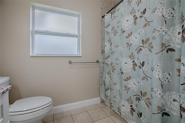 bathroom with a shower with shower curtain, tile patterned floors, and toilet