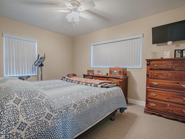 carpeted bedroom featuring ceiling fan and a textured ceiling