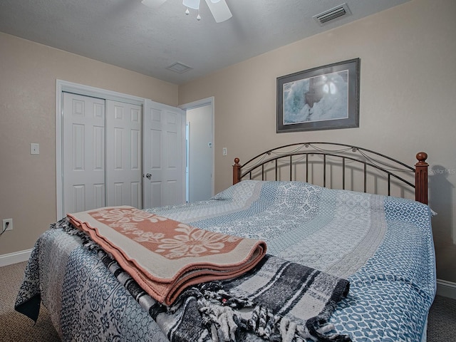 carpeted bedroom featuring a textured ceiling, ceiling fan, and a closet