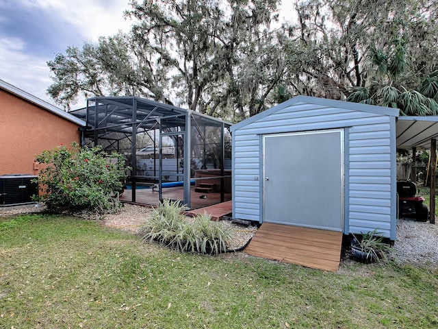 view of outbuilding featuring a swimming pool, a yard, and central AC unit