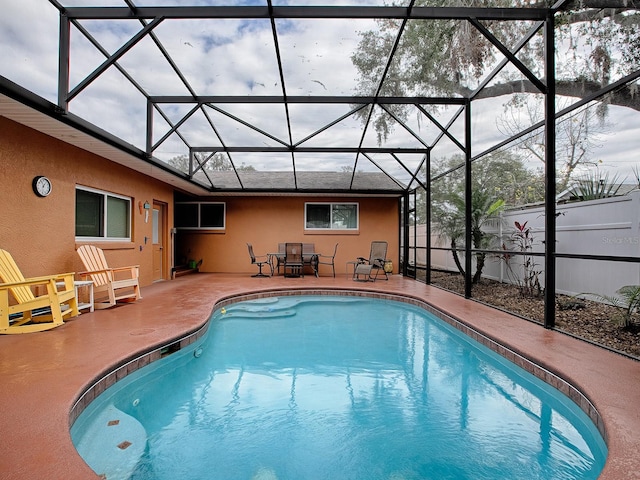 snow covered pool featuring a lanai and a patio area