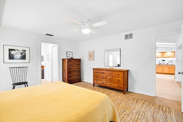 bedroom with light hardwood / wood-style floors, ceiling fan, and ensuite bathroom