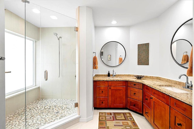 bathroom with walk in shower, vanity, tile patterned flooring, and a wealth of natural light