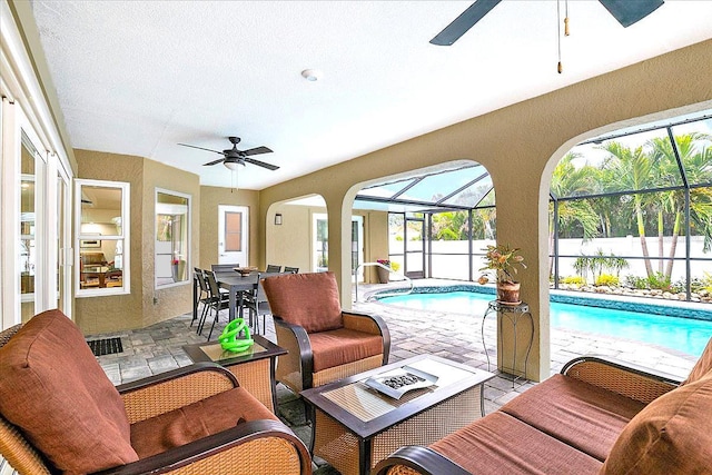 sunroom / solarium with ceiling fan and a swimming pool