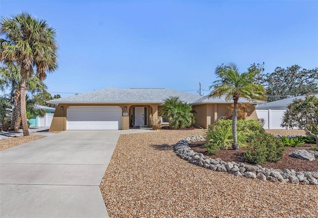 ranch-style home featuring a garage, driveway, fence, and stucco siding