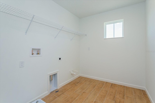 clothes washing area with hookup for a washing machine, hookup for an electric dryer, and light hardwood / wood-style floors