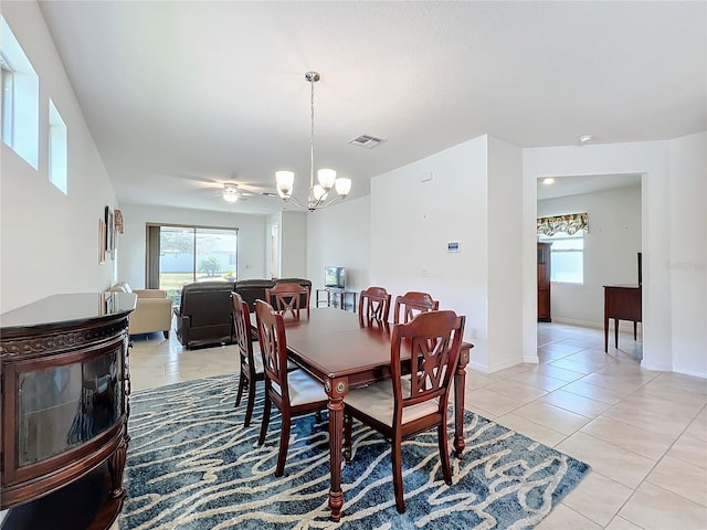 tiled dining room featuring a chandelier