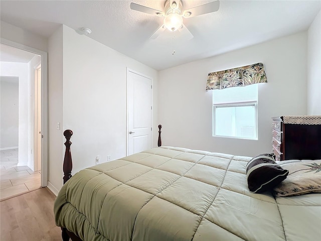 bedroom with ceiling fan, a textured ceiling, and light wood-type flooring