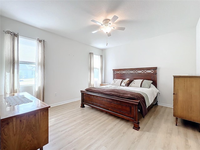 bedroom featuring multiple windows, ceiling fan, and light wood-type flooring